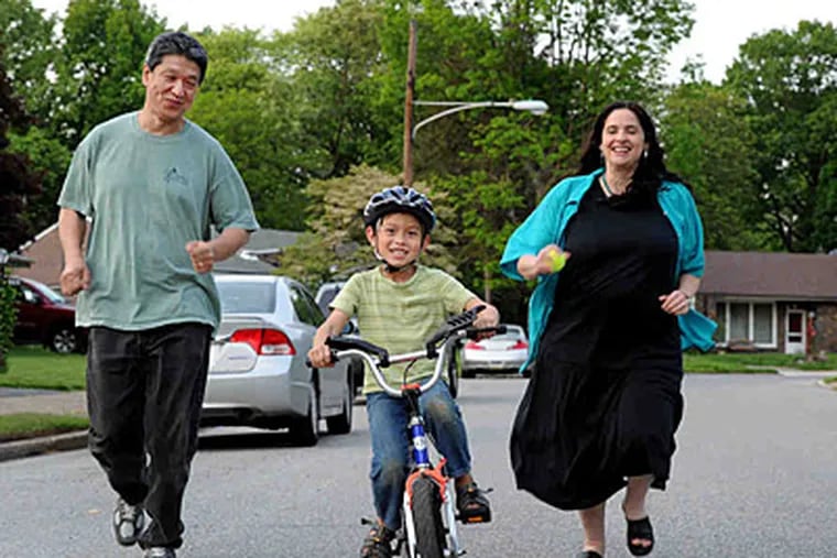 Ben Yoshi, 6, rides his bike as his father, Yukio Tezuka, and mother, Sarah Rosenbaum, run to keep up with him. (Sharon Gekoski-Kimmel / Staff Photographer)