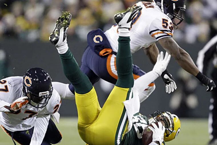 Packers tight end Jermichael Finley is taken down by the Bears' Major Wright (left) and Nick Roach. (AP Photo)