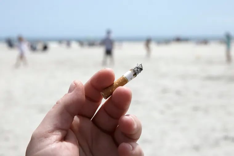 A smoker on the beach in Wildwood Crest smokes in a designated smoking area on Saturday.