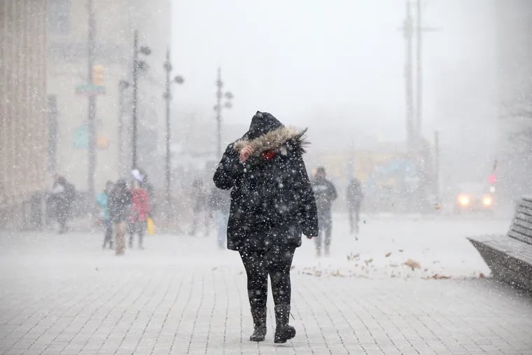 A pedestrian is caught in a snow squall on the campus of Drexel University in Philadelphia on Wednesday, Jan. 30, 2019.