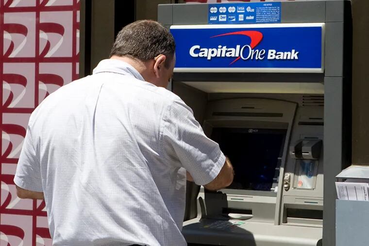 A man uses an automatic teller machine (ATM) at a Capital One bank branch in New York, U.S.. The Virginia-based loan giant, which waged a costly effort to diversify in the 2000s, has also become one of the biggest lenders to Philadelphia construction projects.