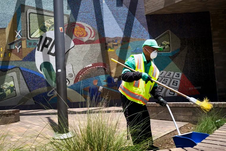 A cleaning crew sweeps up in front of LAPD Central Community Police Station in downtown Los Angeles on Thursday, May 30, 2019. The union that represents the LAPD is demanding a cleanup of homeless encampments in the city after one detective who works downtown was diagnosed with typhoid fever and two others are showing similar symptoms.