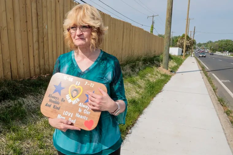 Sharon Rearick with a photo of her son, John, who was killed by a hit-and-run driver in 2012 as he walked along New Falls Road. For 11 years, Rearick fought to have a sidewalk installed on that heavily trafficked road. It officially opens Thursday.