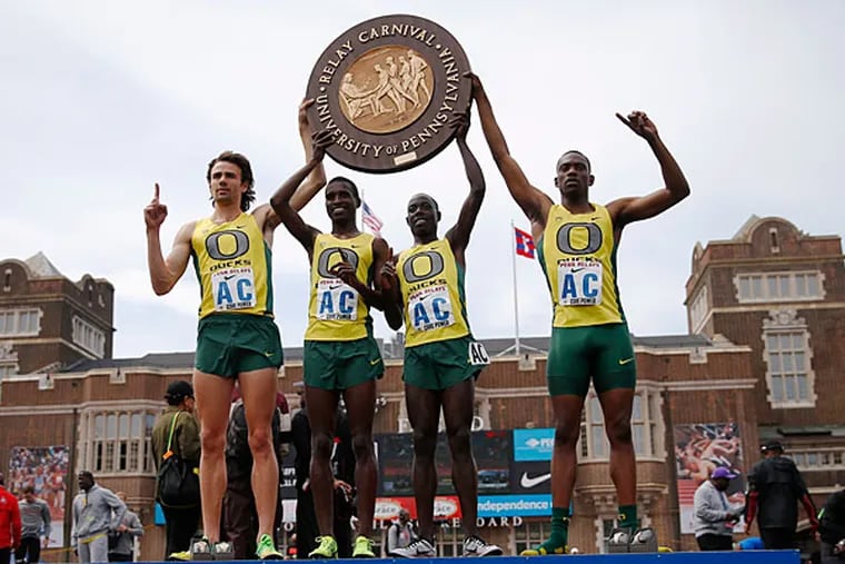 Oregon's Mac Fleet, Boru Guyota, Edward Cheserek and, Mike Berry pose for a photographs on the podium after winning the the College Men's Distance Medley Championship of America at the Penn Relays athletics meet, Friday, April 25, 2014, in Philadelphia. Oregon won with a time of 9:25.40. (Matt Rourke/AP)