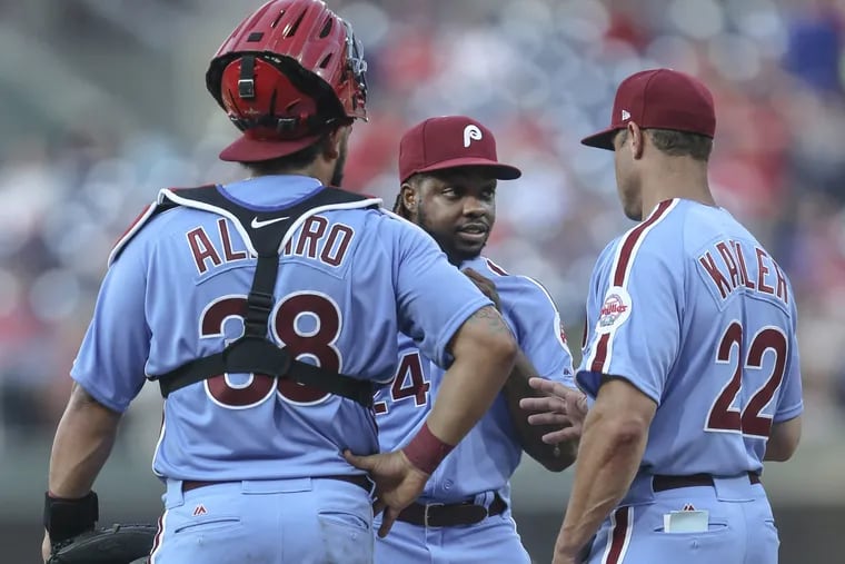 With catcher Jorge Alfaro (left) looking on, Phillies manager Gabe Kapler (right) talks to Roman Quinn during the center fielder's relief appearance Thursday against the New York Mets.