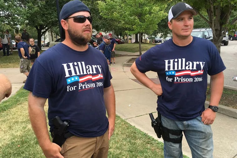 Anti-Hillary Clinton protesters Derek Leeds (left) and Sam Kurk from Central Pennsylvania openly carry firearms in Settlers Park in Cleveland while waiting on the start of a pro-Trump rally on Monday, July 19, 2016.