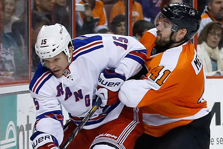 The Rangers' Derek Dorsett, left, and Philadelphia Flyers' Andrej Meszaros battle for the puck during the third period of an NHL hockey game, Sunday, March 2, 2014, in Philadelphia. Philadelphia won 4-2. (Matt Slocum/AP)