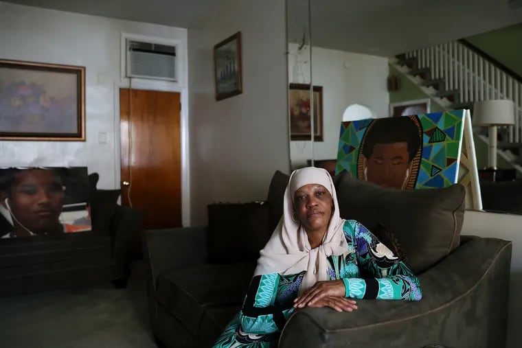Jackee Nichols sits for a portrait next to a painting of her grandson Rasul Benson in her South Philadelphia home on Oct. 23, 2020. Benson was 15 when he was shot and killed at a gas station at 25th Street and Passyunk Avenue in 2018.