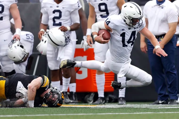 Iowa defensive back Jack Koerner (28) trips up Penn State quarterback Sean Clifford (14) on a run in the first half of an NCAA college football game, Saturday, Oct. 9, 2021, in Iowa City, Iowa.