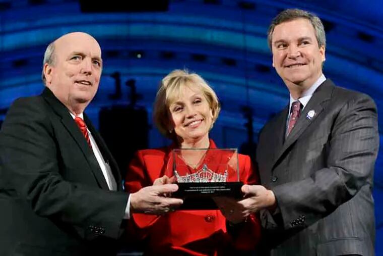 Art McMaster, left, president and CEO of the Miss America Organization, and Sam Haskell, right, chairman of the Miss America Organization Board of Directors, present a Miss America crown to New Jersey Lt. Gov. Kim Guadagno at Atlantic City's Boardwalk Hall. Thursday, Feb. 14, 2013, in Atlantic City, after they announced that the Miss America pageant is returning to Atlantic City. The pageant returns to Atlantic City in September after spending six years in Las Vegas. (AP Photo/Mel Evans)