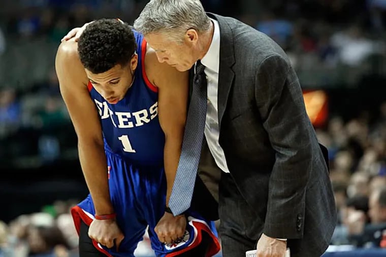 Philadelphia 76ers' Michael Carter-Williams (1) talks to head coach Brett Brown, right, in the second half of an NBA basketball game against the Dallas Mavericks, Thursday, Nov. 13, 2014, in Dallas. Carter-Williams played for the first time since surgery in May to repair the labrum in his right shoulder. He led Philly with 19 points on 6-of-19 shooting, and also had eight rebounds and five assists.The Mavericks won 123-70. (Tony Gutierrez/AP)