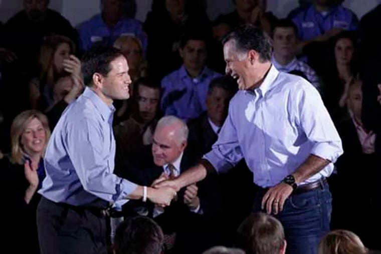 Republican presidential candidate, former Massachusetts Gov. Mitt Romney shakes hands with Sen. Marco Rubio, R-Fla., after Romney was introduced by Rubio during a town hall-style meeting in Aston, Pa., Monday, April 23, 2012. (AP Photo/Jae C. Hong)
