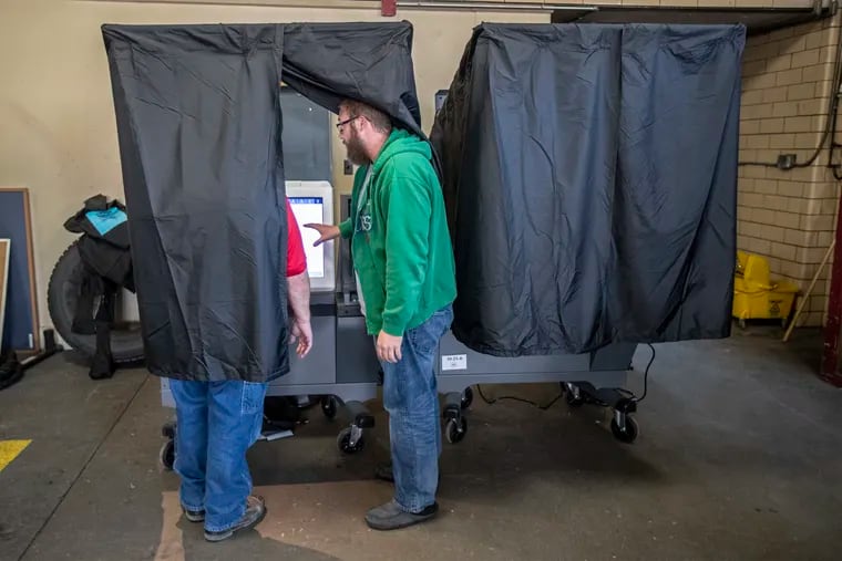 At the polling place at Engine 49 Firehouse at 13th and Shunk, a Philadelphia voter gets instruction from John Chambers (right), the majority inspector for Ward 39, Division 25, on how to use new voting machines put in place by the city earlier this month.