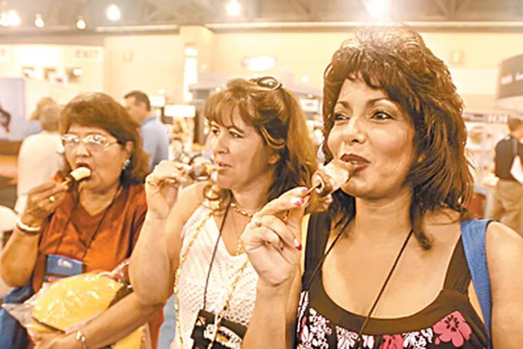 Judy Houston, Janet Sanchez and Debbie Trujillo all with school districts in New Mexico enjoy chocolate covered frozen bananas during the school School Nutrition Association at the Convention Center. (Ron Tarver / Inquirer)