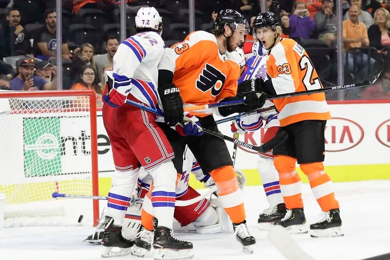 Flyers center Kevin Hayes (center) puts a first-period deflection past Rangers goalie Igor Shesterkin, much to the delight of teammate Oskar Lindblom (right) on Saturday night at the Wells Fargo Center.