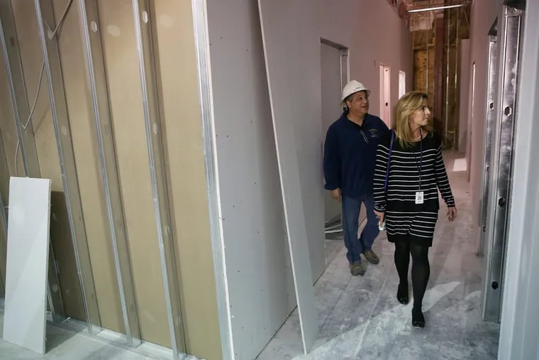 Grace MacAulay, section chief of the Special Victims Unit of the Camden County Prosecutor’s Office,  walks through the    Child Advocacy Center under construction in downtown Camden. The facility is expected to open in spring. Behind MacAulay is project superintendent Rich Bushby, of Newport Construction.