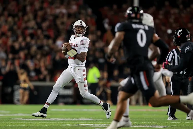 Temple quarterback D'Wan Mathis, left, scrambles looking for a receiver during the first half against Cincinnati Friday night. The Owls were blown out, 52-3.