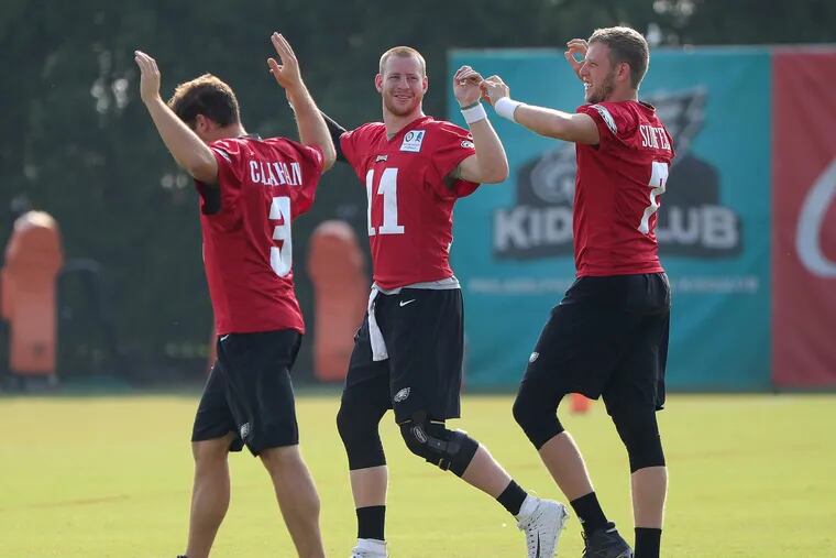 Eagles' quarterback Joe Callahan, left, Carson Wentz, center, and Nate Sudfeld, right, warm up during Eagles training camp at the NovaCare complex in Philadelphia, PA on August 7, 2018. DAVID MAIALETTI / Staff Photographer