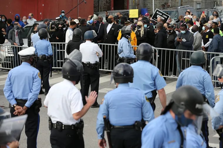 Police line up as members of the Black clergy protest outside the 18th police precinct in Philadelphia on Oct. 27, 2020, the day after Walter Wallace Jr. was shot and killed by police officers.