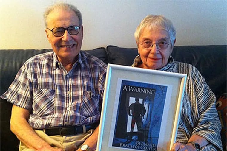Bernie Cohen, with his wife, Selma, holding a framed cover of his new e-book. Reviews of the book seem to be helping sales, but Bernie's elderly friends aren't latching on to its digital medium. (Ronnie Polaneczky / Staff)