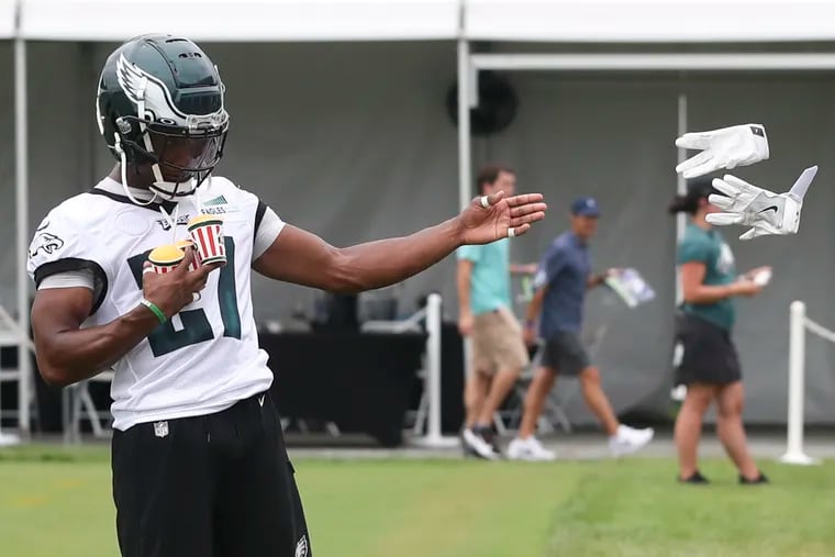 Eagles cornerback Zech McPhearson throws his gloves to a fan while carrying Rita’s ice after the second day of training camp at the NovaCare Complex in South Philadelphia.