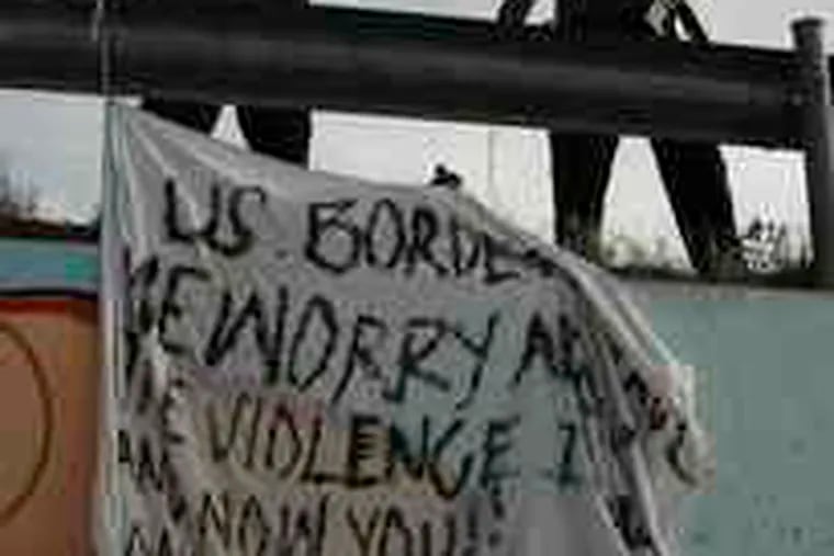 Mexican police bring down a banner hung at the site of the shooting accusing U.S. Border Patrol agents of murder.