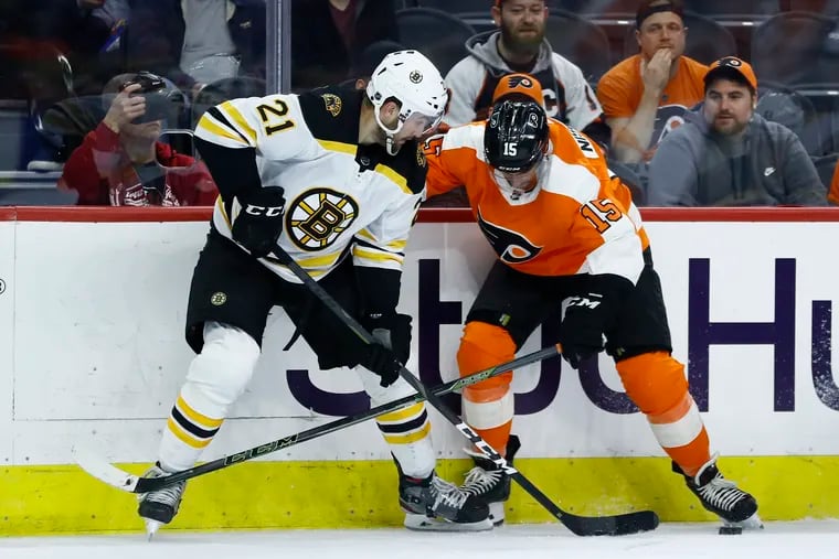 Boston's Nick Ritchie (left)  and the Flyers' Matt Niskanen battling for the puck during a late-season game. Niskanen prefers a 16-team playoff format over a 24-team field.