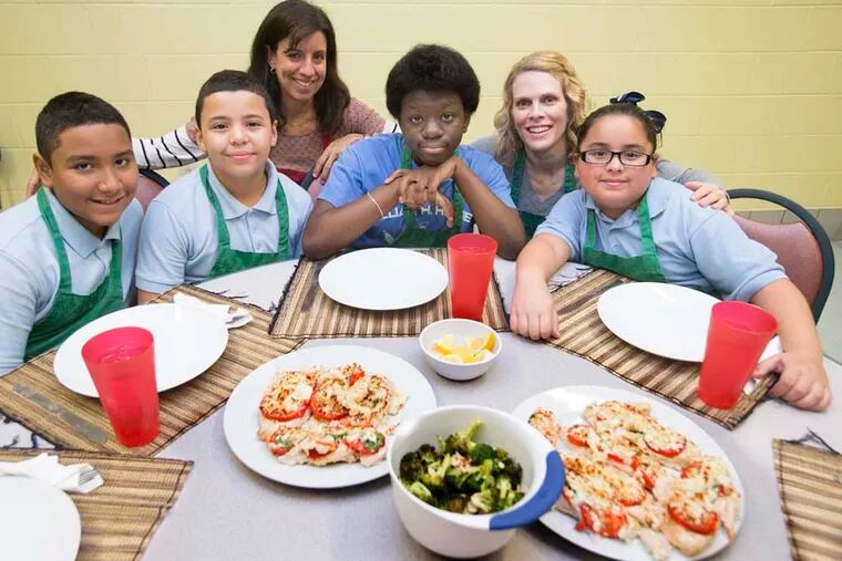 Students and volunteers at the Willam Hunter Elementary School cook a unique version of chicken parmigiana.  L-R: Jeremy Santiago, Elias Figuero, Kristin Stitz, Talitha Rivera, Dana Srodes, and  Janalys Torres with the finished plates of chicken parmigiana and broccoli.   ( CHARLES FOX / Staff Photographer )