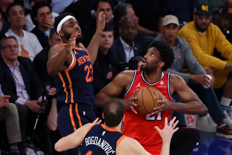 Sixers center Joel Embiid grabs the basketball against New York Knicks center Mitchell Robinson and forward Bojan Bogdanovic during Game 2 of the first round NBA Eastern Conference playoffs at Madison Square Garden in New York on Monday, April 22, 2024.