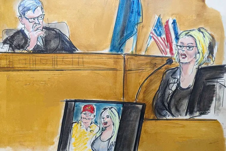 In this courtroom sketch, Stormy Daniels testifies on the witness stand as Judge Juan Merchan looks on in Manhattan criminal court, Tuesday, May 7, 2024, in New York.. A photo of Donald Trump and Daniels from their first meeting is displayed on a monitor.