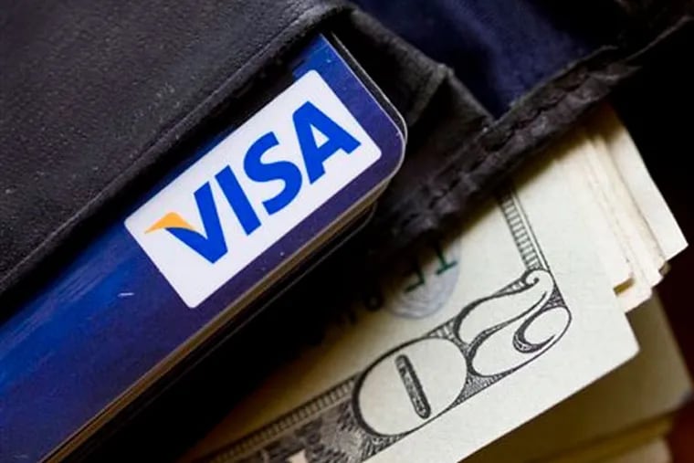 A wallet containing cash and a Visa card is displayed Wednesday, Feb. 2, 2011, in Surfside, Fla. (AP Photo/Wilfredo Lee)