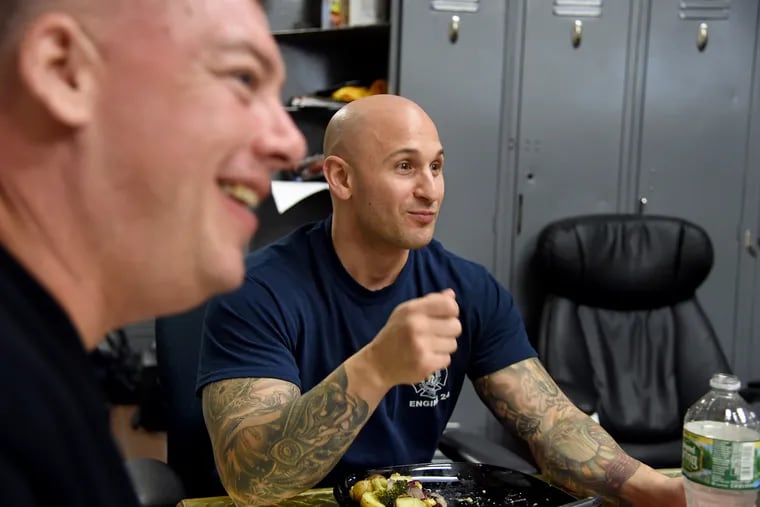 Engine 24 firefighters Lieutenant Henry Brolly (left) and Firefighter Rich Rizzi (right) eat dinner at the firehouse.