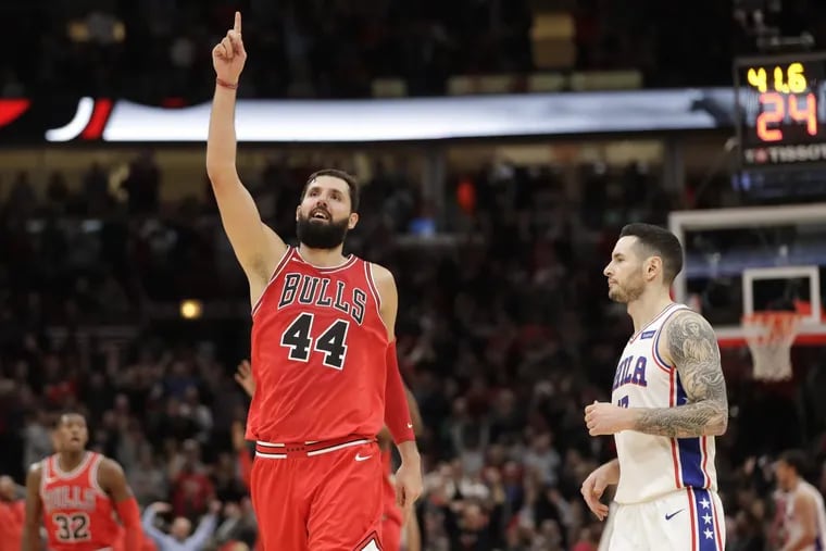 The Bulls' Nikola Mirotic, celebrating his team's pulling away from the 76ers as Sixers guard JJ Redick looks on during the second half.