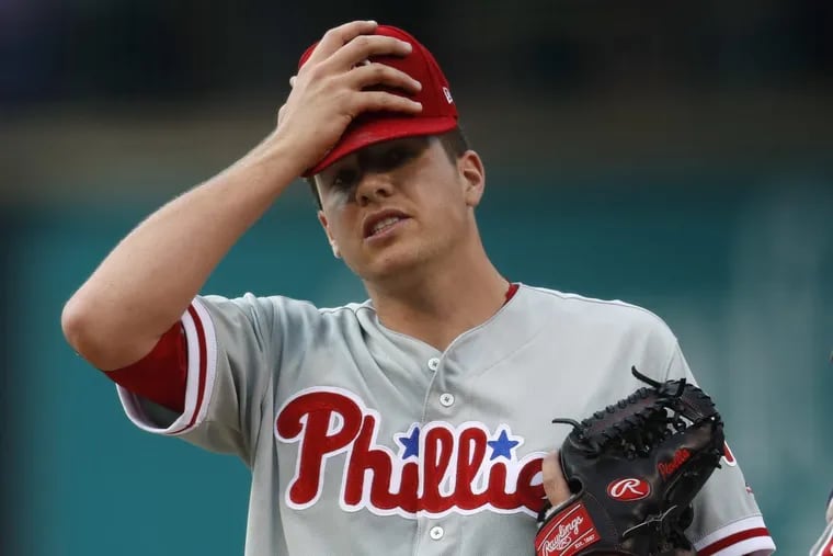 Phillies starting pitcher Nick Pivetta holds his head after giving up a single to Rockies Gerardo Parra to allow in two runs in the first inning of a baseball game on Saturday.