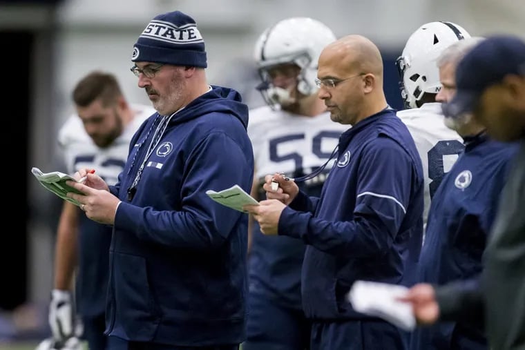 Penn State offensive coordinator Joe Moorhead, front left, and coach James Franklin check notes during NCAA college football practice Wednesday, Nov. 15, 2017, in State College, Pa.