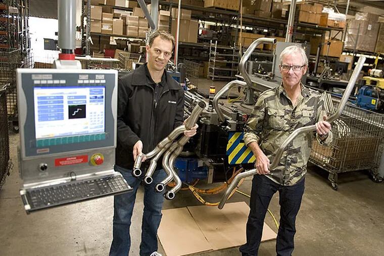 Two Brothers Racing CEO Jeff Whitten, left, and founder Craig Erion in their Santa Ana, Calif., shop with an American-made CNC bending machine, which forms motorcycle exaust pipes. "If the Chinese want to bend quality tubing they buy American machines," Whitten said. (Jebb Harris/Orange County Register/MCT)