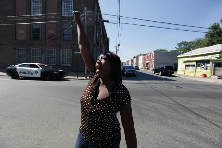 Where the shooting happened, at Eighth and Spruce Streets, neighbor Renee Vaughns celebrates news of the suspect's arrest.