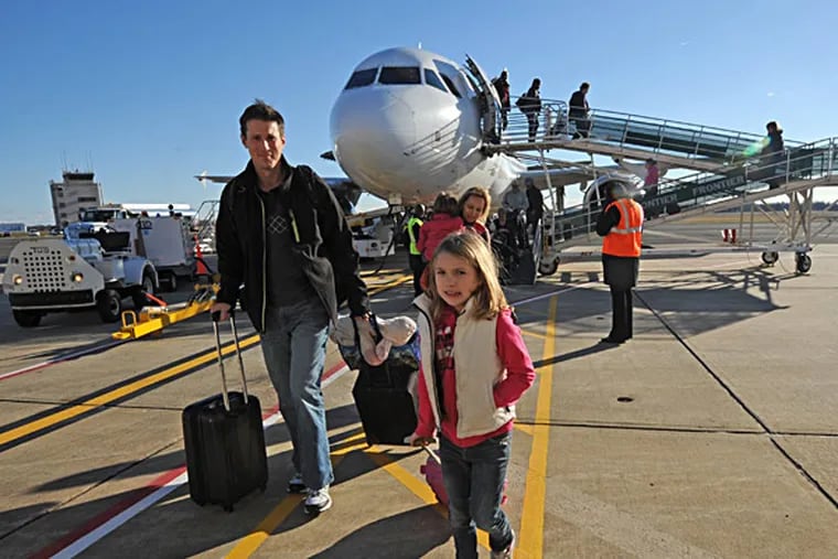 Emma Smith, 7, of Pennington, N.J., and her father, Brian, head home after their flight from Orlando on Friday. APRIL SAUL / Staff Photographer
