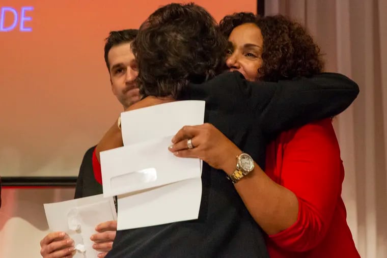Nicole Green (L) hugs Ann Baiada in the Bellevue Hotel 's grand ballroom. Mark Baiada, founder of the Bayada home healthcare agency, announced at the party that he is giving away $20 million to his employees.