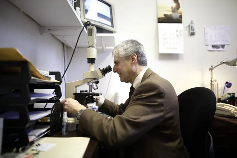 David Dvorin, the region’s official pollen counter, examines specimens for his daily count in Center City.