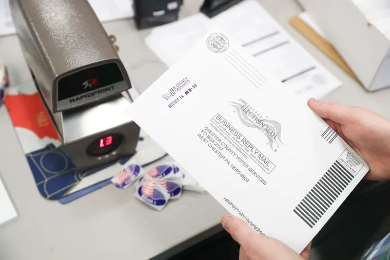 An election worker time-stamps a mail ballot at the Chester County Government Services Building in West Chester, Pa., in this 2022 file photo.