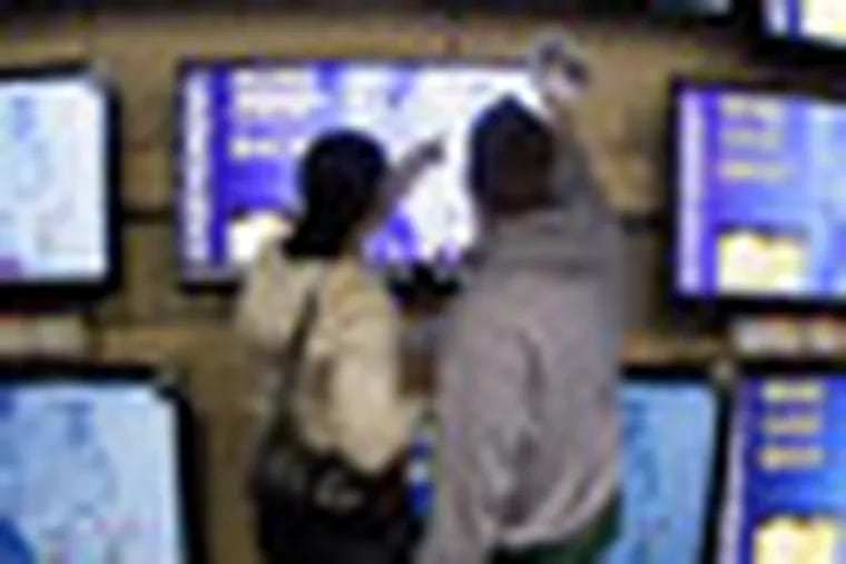 FILE - In this Nov. 25, 2011 file photo, shoppers look at televisions displayed at a Best Buy store, in Brentwood, Tenn. Weak demand for pricey flat-screen TVs and notebook computers helped push Best Buy Co.'s fourth-quarter net income down 16 percent. (AP Photo/Mark Humphrey, File)