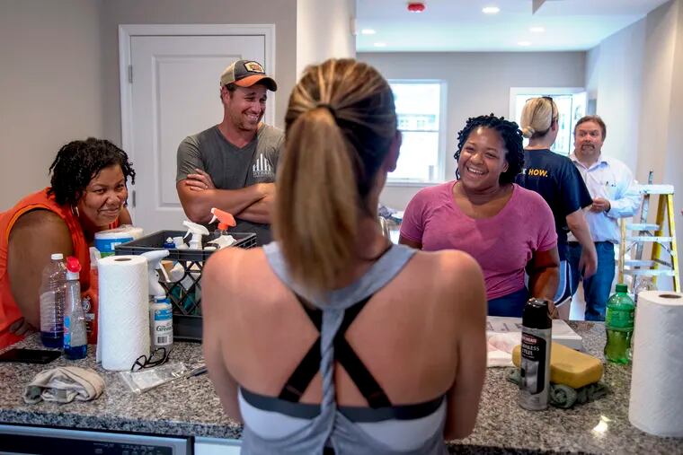 New homeowner Lois Napper (right) talks with Rita Calicat (left), a social worker with Habitat for Humanity, and HOW volunteers and board members Anthony and Dominique Delgott in her new kitchen as they help prep the house for move in.