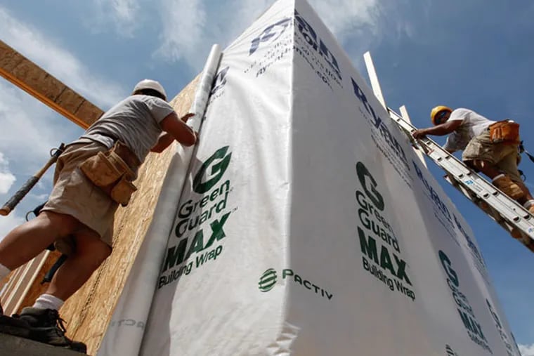 In this May 16, 2012 file photo, construction workers wrap a home in protective sheeting as they frame a new home in Chester, Va. After a six-year slump that sent more than 4 million homes into foreclosure and shrank home prices about one-third nationwide, the U.S. housing market began to recover in 2012. Modest job gains and record-low mortgage rates fueled demand. (AP Photo/Steve Helbe, File)