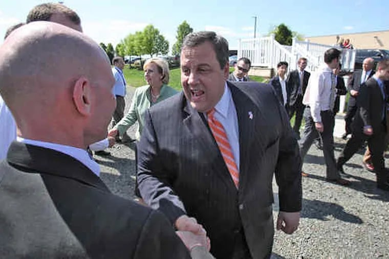 In Moorestown, Gov. Christie pumps the hand of Steve Lundholm of Lockheed Martin's business development office.Christie hailed the national defense contractor as a company that has put down &quot;deep roots&quot; in New Jersey.