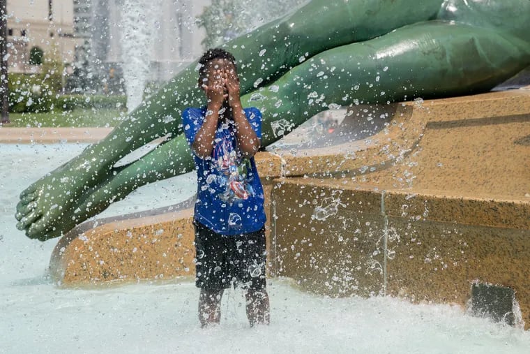 Catanna Lawson, 7, cools off from the hot weather at Logan Square.