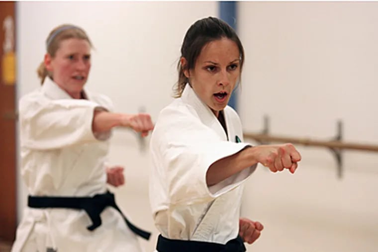 Sarah Adams, left, a second-degree blackbelt and Isabelle Guimont, a first-degree blackbelt, practice Karate in San Diego, Calif. Adams and Guimont will auction a number of women's self-defense classes and donate the proceeds to charity. (Sean Masterson/Los Angeles Times)