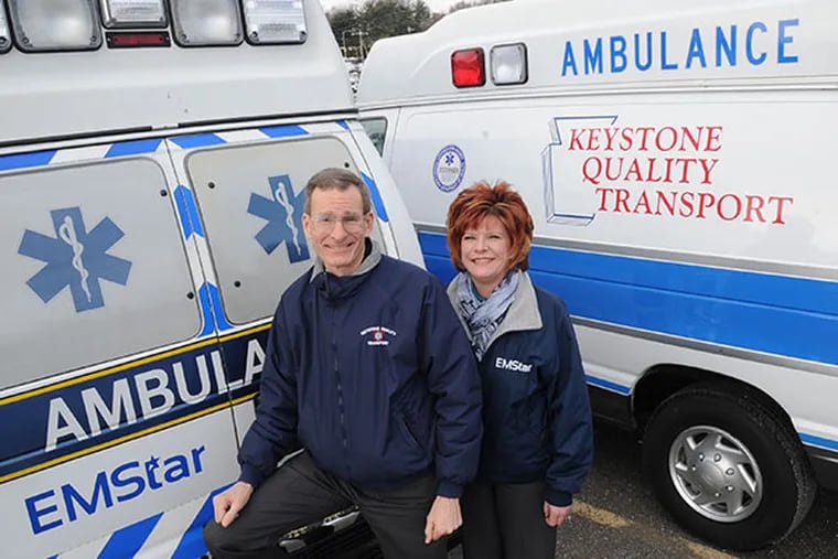 Steve Barr, left, President and CEO of Keystone Quality Transport, and Suzannae Shubert, the Customer Care Manager, stand between two ambulances Feb. 27, 2014.  ( CLEM MURRAY / Staff Photographer )