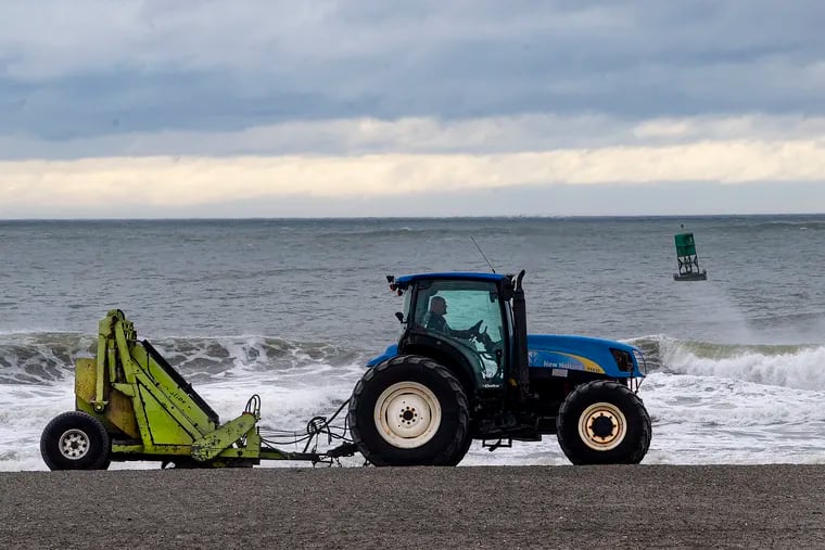 A tractor combs the sand to clean the beach in Atlantic City last July.