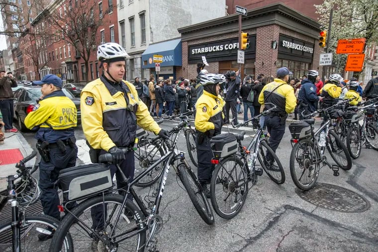 Bicycle police officers keep watch over protesters, who demonstrated outside the Starbucks  where an employee called the police on two black men who were sitting in the cafe.